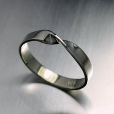 a silver ring with a curved design on it