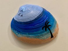 a painted rock with a palm tree on it