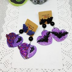 Resin heart earrings with Halloween spooky ghosts and bats - creepy cute holographic glitter jewelry The perfect pair of pendant earrings for Halloween night! They are entirely made in resin, glass pigments and holographic glitters, cast in premium silicone molds. Each one of them is one of a kind since I mix resin with pigments for every single pair of earrings. Nickel-free studs with cute colorful resin bats. Measures: approx. 6.5 cm  All shipments will be made by Postapriority International, Heart-shaped Halloween Party Earrings, Halloween Party Heart-shaped Earrings, Purple Earrings For Halloween Party, Halloween Resin Earrings, Halloween Resin, Alt Clothing, Glitter Jewelry, Boutique Ideas, Holographic Glitter