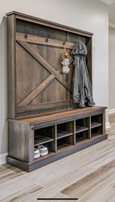 an entryway with a bench, coat rack and shoes on the floor next to it