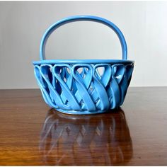 a blue basket sitting on top of a wooden table