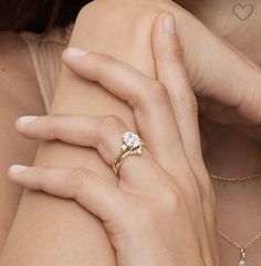 a close up of a person's hand with a ring on her finger and a diamond