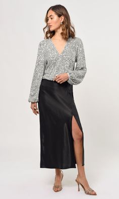 This blouse is designed with long puff sleeves and sequins for a sophisticated style with a little extra sparkle. Its lightweight fabric makes it comfortable to wear, while the unique design adds a touch of class to any look. Blouse Sequin Long sleeve V-neck Self: 95% Polyester, 5% Spandex Lining: 95% Polyester, 5% Spandex Contrast: 100% Polyester Length: 19 1/2" Chest: 17 1/2" Hand wash in cold water. Lay flat to dry. Low iron. Style #: G239T6879 Casual Sequined V-neck Top, Elegant Button-up Sequin Blouse, Glamorous V-neck Shimmer Top, Glamorous Semi-stitched Sequin Blouse, Luxury Sequined V-neck Tops, Sequins Blouse, Tops And Blouses, Long Puff Sleeves, Low Iron