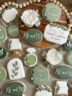 decorated cookies are arranged on a platter with wedding names and date written on them