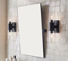 a bathroom mirror mounted to the side of a wall