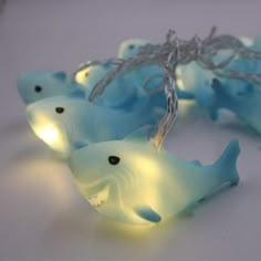 some little lights that are on top of a white table and one has a fish in it