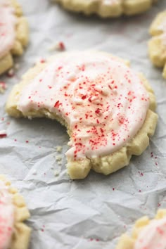 a cookie with white frosting and red sprinkles