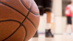 a close up view of a basketball on the court with other players in the background