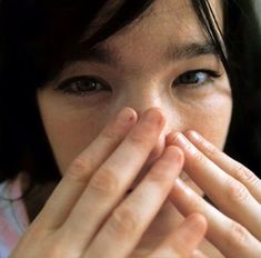 a woman covering her mouth with both hands