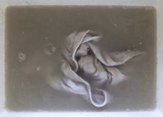 an old photo of a cloth hanging from a hook on a wall with water droplets around it