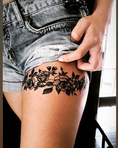 a woman is showing off her thigh with flowers on it and the bottom half of her leg