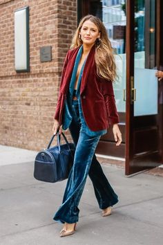 a woman is walking down the street with her hand in her pocket