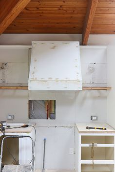 an unfinished kitchen with white cabinets and wood ceilinging in the process of remodeling