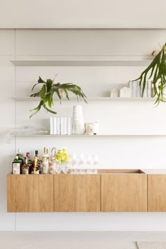 an air conditioner sitting on top of a wooden cabinet next to a green plant