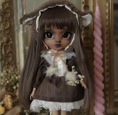 a doll with long hair wearing a brown dress