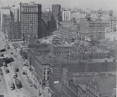 an old black and white photo of a city with tall buildings in the middle of it