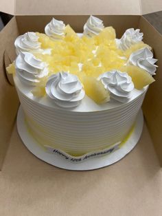 a white cake with yellow frosting in a box