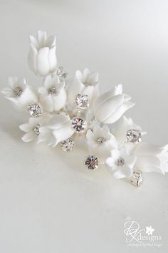 white flowers with crystal stones on them are sitting next to each other in front of a white background