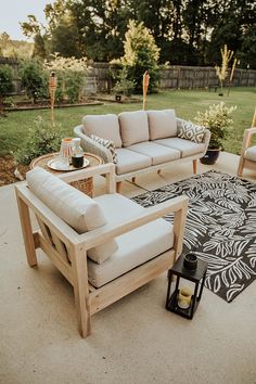 an outdoor living area with couches, chairs and table in the middle of it