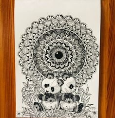 two pandas are sitting in the grass under a large flower design on a white paper