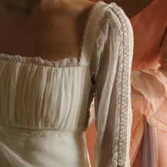 the back of a woman's white dress with long sleeves