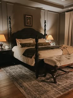 a large bed sitting on top of a wooden floor next to two lamps and a window