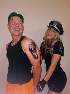 a man and woman posing for a photo with tattoos on their arms, both wearing police uniforms