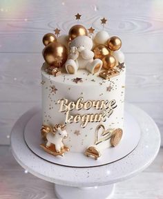 a white and gold birthday cake with teddy bears on top