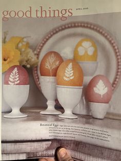 a person holding up a magazine with three eggs in the shape of leaves on them