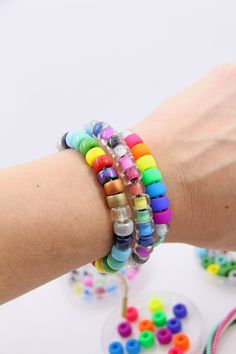 a woman's arm with several bracelets on it and beads around the wrist