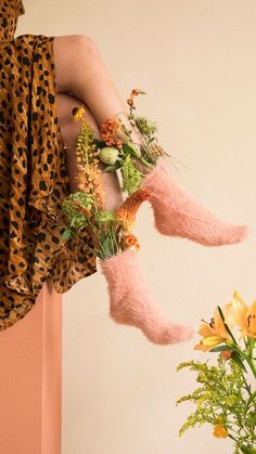 a woman's legs with flowers and plants on them