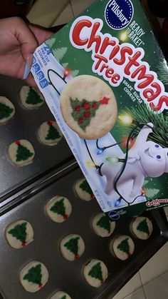 a box of christmas tree cookies sitting on top of a cookie sheet