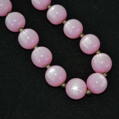 "This vintage necklace is lovely! Single stranded, it features pink moonglow plastic beads (possibly lucite), small metal bead spacers, and has a spring ring clasp. Beautiful! Measures 24.25\" from end to end. Condition : Good.. There's light wear on the beads." Pink Polished Round Bead Necklaces, Pink Round Polished Bead Necklaces, Pink Polished Round Beads, Pink Necklaces With Spacer Beads, Pink Round Beaded Necklaces With Spacer Beads, Vintage Pink Beaded Necklace As A Gift, Vintage Pink Single Strand Jewelry, Vintage Pink Beaded Necklaces, Vintage Pink Beaded Necklace