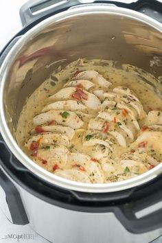 a pot filled with chicken and sauce on top of a stove