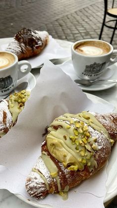 two pastries are on a plate with coffee