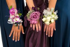 three bridesmaids in purple dresses holding bouquets of flowers and their hands together