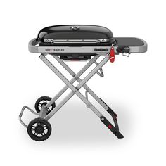 an image of a barbecue grill with wheels on the side and red handlebars