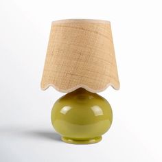 a green table lamp with a beige shade on it