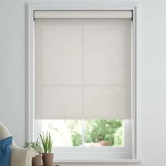 a window with white blinds and a plant in front of it on the windowsill