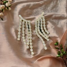 Make a statement with these stunning cascading rhinestone dangle earrings. Perfect for special occasions such as weddings, parties, or festive celebrations, these earrings are designed to dazzle. The intricate design features multiple strands of shimmering rhinestones that catch the light with every movement, adding a touch of glamour to any outfit. Crafted with care, these earrings are lightweight yet durable, ensuring comfort throughout your event. Whether you're looking to elevate your evenin Party Diamond Earrings With Cubic Zirconia, Party Dangle Diamond Earrings, Dazzling Crystal Drop Chandelier Earrings, Glamorous Cubic Zirconia Drop Chandelier Earrings, Sparkling Cubic Zirconia Earrings For Party, Dangle Crystal Earrings With Bling For Anniversary, Crystal Drop Earrings For Bridal Glamorous Events, Crystal Drop Earrings For Glamorous Events, Dazzling Diamond Crystal Earrings For Party