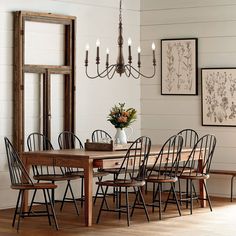 a dining room table with chairs and a chandelier hanging from the ceiling above it