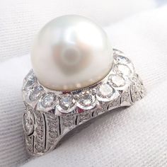 About This Piece: This Vintage Estate 18k White Gold Diamond 12.5mm Pearl Ring features a large, lustrous 12.5mm pearl set in a beautifully crafted 18k white gold cocktail ring. The pearl is accentuated by a halo of sparkling diamonds, adding a touch of elegance and sophistication to this timeless piece. Metal: 18k White Gold Stone: Diamonds: Approx 2ctw Size: 6, Resize Available Pearl: Bluish Silver High Luster 12.5mm Pearl Weight: 13.1g Hallmarks: 18k 89192 3227medd Pearl Cocktail Ring, Chanel Ring, Watch Cufflinks, Hermes Jewelry, Gold Cocktail Ring, Gold Cocktail, Gold Stone, Pearl Set, Cartier Ring