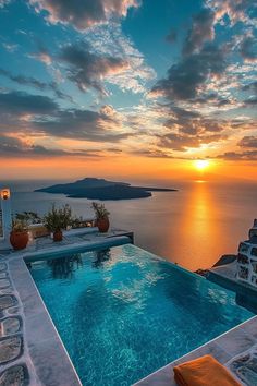 an outdoor swimming pool overlooking the ocean at sunset