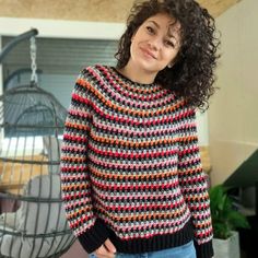 a woman standing in front of a bird cage with her hands on her hips and smiling at the camera