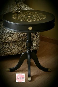 a black table sitting on top of a hard wood floor next to a couch and chair