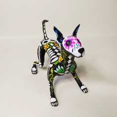 a figurine of a dog with flowers painted on it's face and tail