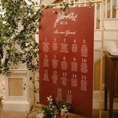 a table with a calendar on it and flowers in vases next to the wall