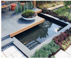 an outdoor garden with water and plants in it