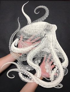 an octopus mask is being held by someone's hand with the tentacles attached to it