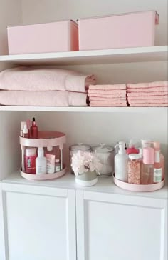 the shelves are filled with pink towels and other bathroom items